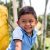 Portrait of a latin boy smiling. Happy child enjoying a nice park surrounded by nature.